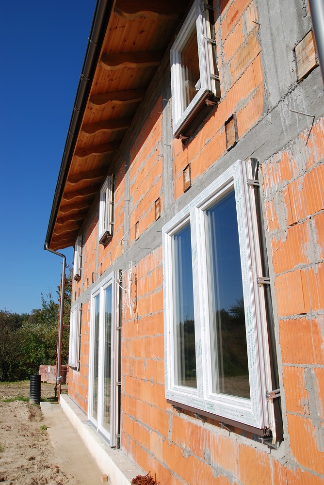 Widoczny charakterystyczny montaż okien na wspornikach - w połączeniu z zastosowaniem taśm systemowych uszczelniających i ściśle dolegającego ocieplenia tworzą tzw. ciepły montaż okna.